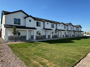 Exterior space featuring a front lawn, a residential view, and stone siding