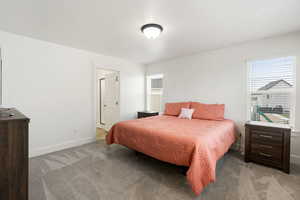 Bedroom featuring light carpet and baseboards