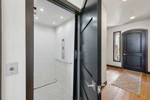 Foyer entrance with recessed lighting, elevator, and light wood-style floors