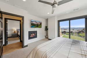Bedroom with wood finished floors, visible vents, a tiled fireplace, and recessed lighting