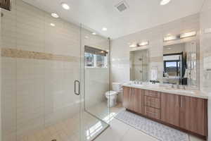 Bathroom with tile patterned floors, recessed lighting, double vanity, and a sink