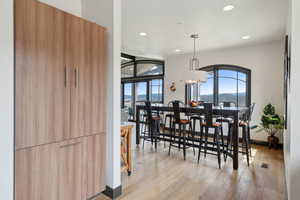 Dining area with visible vents, arched walkways, baseboards, recessed lighting, and light wood finished floors
