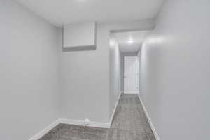 Corridor with light carpet and baseboards