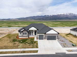 Ranch-style house featuring concrete driveway, a mountain view, and a garage