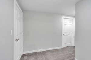 Empty room featuring baseboards and carpet