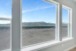 Interior space featuring baseboards, a rural view, and a mountain view