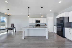 Kitchen with dark stone countertops, recessed lighting, a chandelier, appliances with stainless steel finishes, and a sink