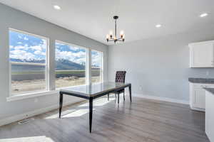 Dining room featuring a chandelier, visible vents, light wood-style flooring, and baseboards