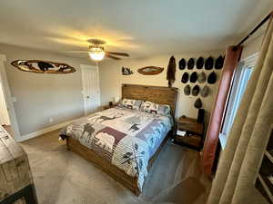 Bedroom with ceiling fan, baseboards, and carpet floors