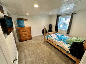 Bedroom featuring carpet, recessed lighting, baseboards, and a textured ceiling
