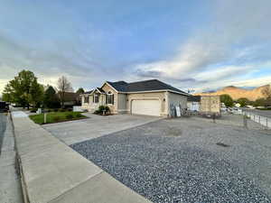 Single story home with a garage, fence, stucco siding, and driveway
