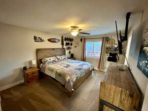 Carpeted bedroom with baseboards and a ceiling fan