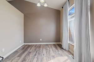 Unfurnished room featuring wood finished floors, visible vents, and baseboards