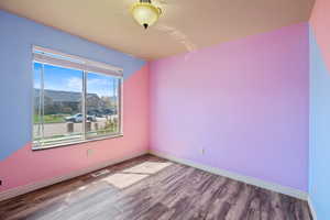 Unfurnished room featuring baseboards, visible vents, and wood finished floors