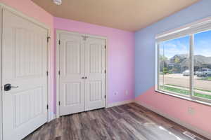 Unfurnished bedroom featuring baseboards, visible vents, wood finished floors, and a closet