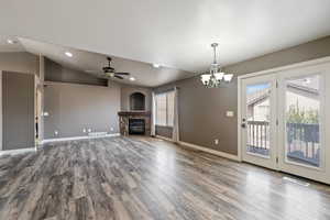 Unfurnished living room with visible vents, a healthy amount of sunlight, and a stone fireplace