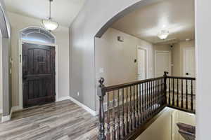 Entryway with wood finished floors, baseboards, and arched walkways