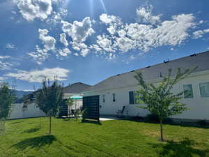 Back of property featuring a lawn and fence