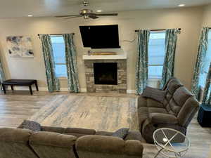 Living room with recessed lighting, a ceiling fan, wood finished floors, and plenty of natural light