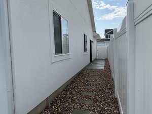 View of home's exterior with stucco siding and fence