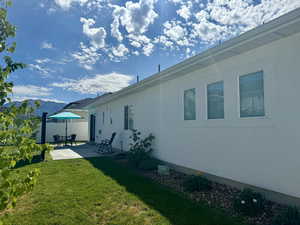 Back of property featuring a yard, fence, and a patio area