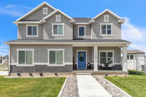 Craftsman house featuring covered porch, brick siding, fence, and stucco siding