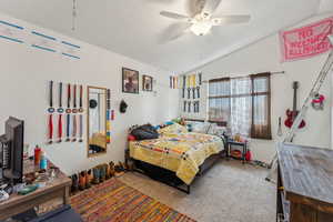 Bedroom featuring vaulted ceiling, carpet, and a ceiling fan