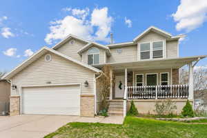 View of front of home with concrete driveway, an attached garage, brick siding, and covered porch