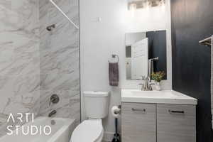Bathroom #2 by kitchen featuring vanity, shower / tub combination, and toilet