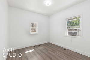 Unfurnished bedroom #4 with cooling unit, wood finished floors, visible vents, and baseboards, closet