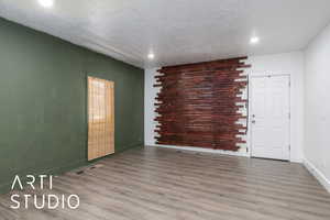 Empty room featuring recessed lighting, wood finished floors, a textured ceiling, and baseboards