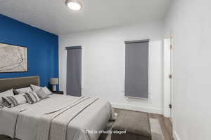 Primary Bedroom #2  featuring baseboards, wood style finished floors, and a textured ceiling, closet and en suite bathroom.