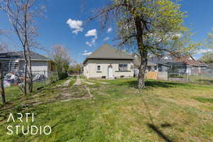 Rear view of house with a yard, a fenced backyard, and a residential view