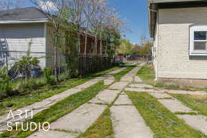 View of back fenced yard featuring two parking pads.