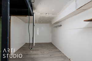 Unfinished below grade storage area with partial wood finished floors