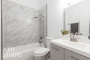 Full en suite bathroom fattached to primary bedroom #2 eaturing washtub / shower combination, vanity, and toilet