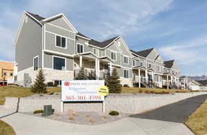 View of side of property featuring board and batten siding, a residential view, cooling unit, and stone siding