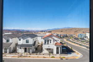 Exterior space featuring a tiled roof, a balcony, a mountain view, and a residential view