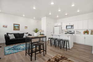 Dining area with baseboards, visible vents, light wood-style floors, and recessed lighting
