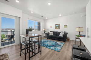 Living area with visible vents, light wood-type flooring, recessed lighting, and baseboards