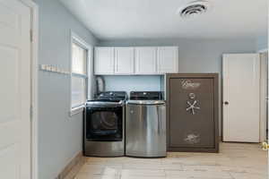 Clothes washing area with cabinet space, independent washer and dryer, visible vents, baseboards, and wood finish floors