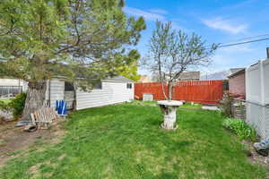 View of yard featuring fence and an outdoor structure