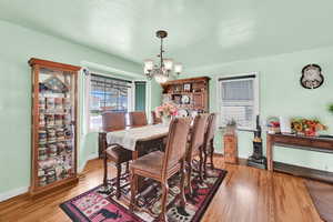 Dining space featuring baseboards, an inviting chandelier, and light wood-style flooring