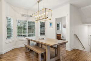 Dining space with a chandelier, hardwood / wood-style flooring, and baseboards