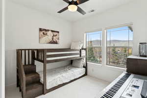 Carpeted bedroom featuring a ceiling fan and visible vents
