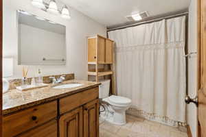 Bathroom with visible vents, a shower with shower curtain, toilet, vanity, and tile patterned flooring