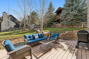 Wooden terrace with outdoor lounge area, a yard, and a fenced backyard