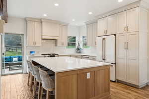 Kitchen featuring light wood-style flooring, recessed lighting, high end fridge, and a kitchen island