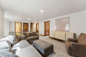 Living room featuring recessed lighting, light carpet, and baseboards