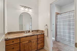 Bathroom with shower / bath combo, toilet, and vanity